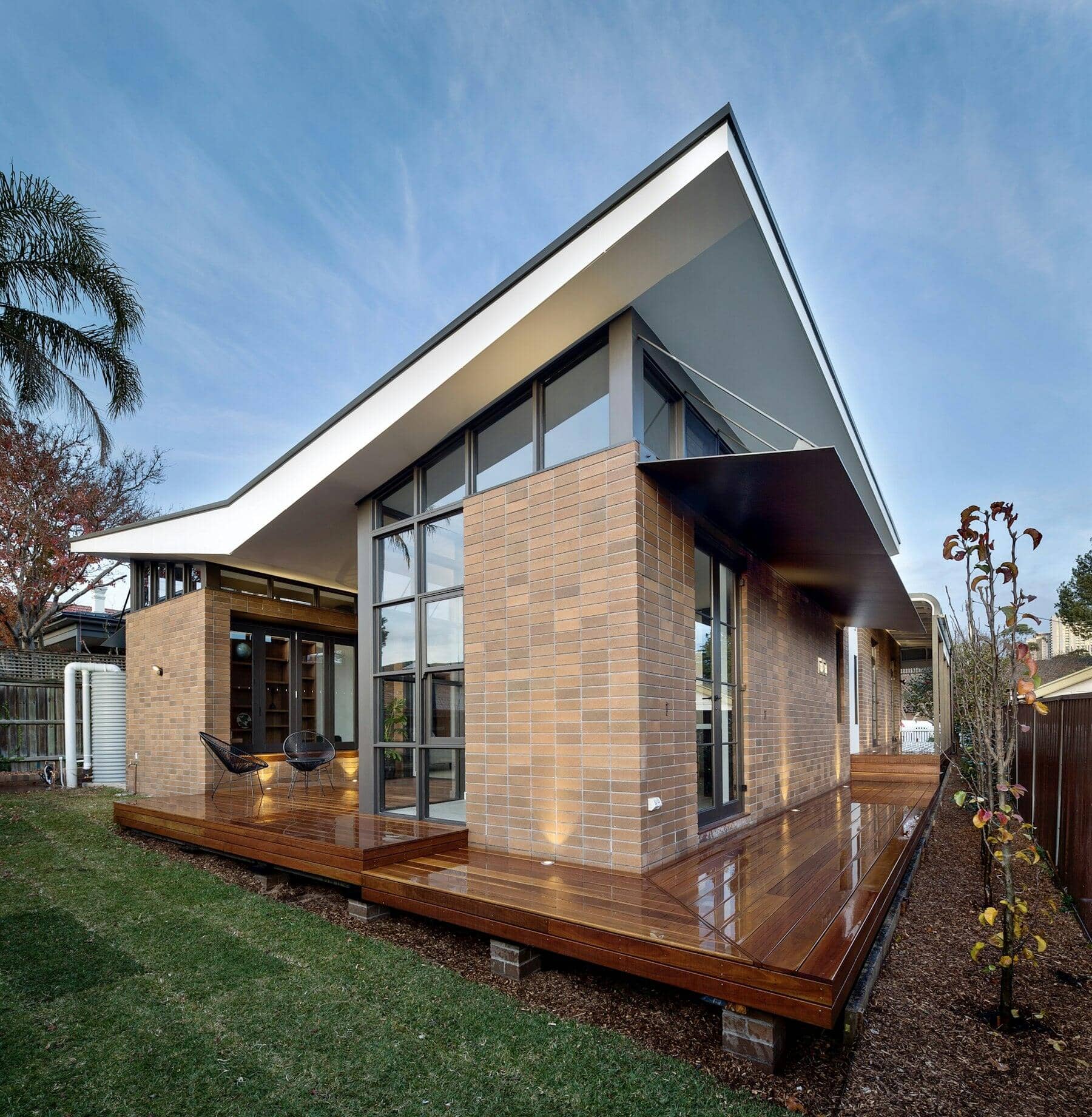 Brick and glass home addition with a skillion roof and timber deck
